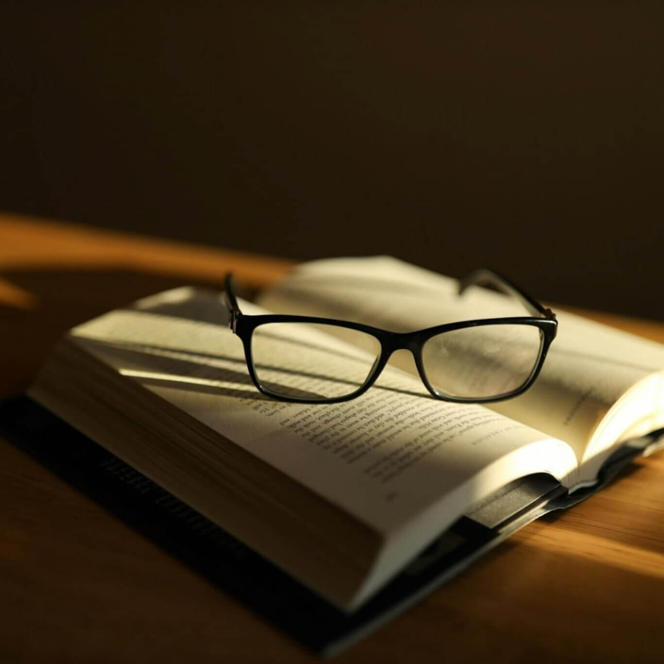 Libro abierto con lentes sobre una mesa con luz cálida, imagen sobre el estudio y la supervisión de casos clínicos